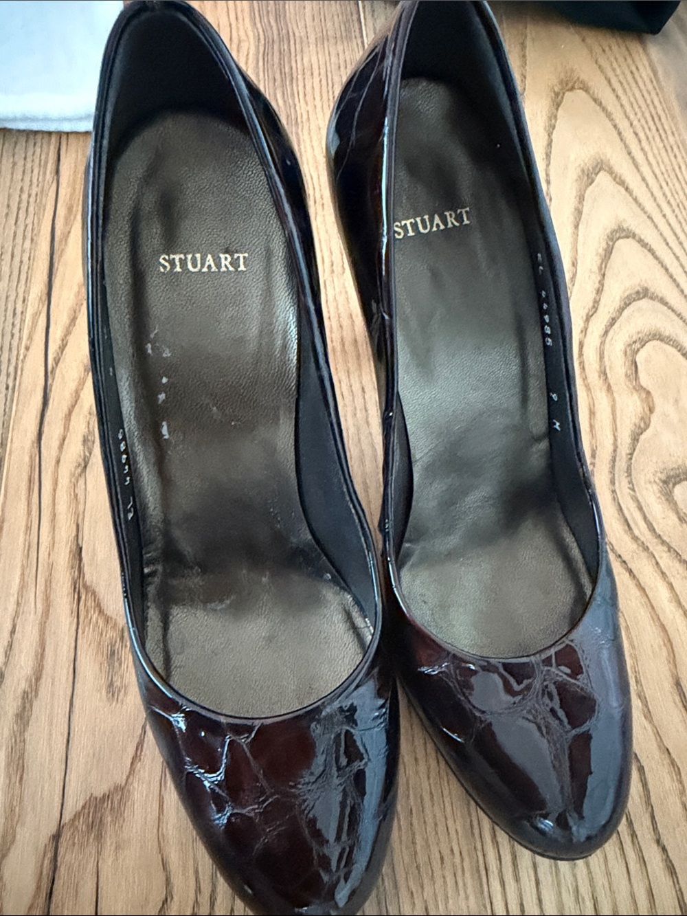 Stuart Weitzman women's platform pumps in a dark, glossy, textured finish